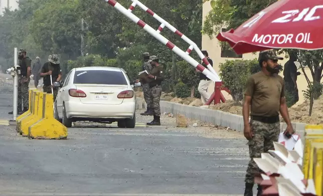 Paramilitary soldiers frisk a car at a checkpoint at Wagah, a joint border crossing point on the Pakistan and India border, near Lahore, Pakistan, Thursday, May 1, 2025.(AP Photo/K.M. Chaudary)