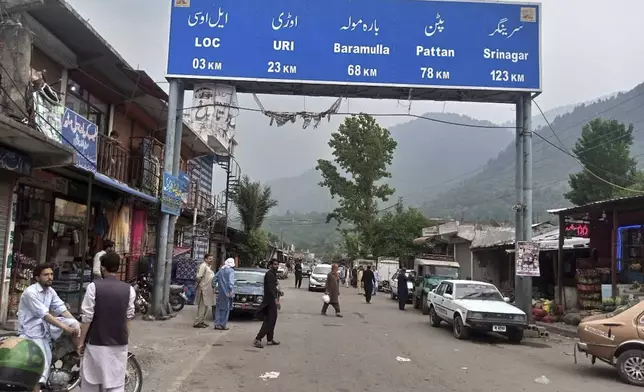 Local residents walk through the main bazaar of Chakothi, near Line of Control, the de facto border dividing Pakistan and Indian Kashmir, some 61 kilometers (38 miles) from Muzaffarabad, the capital of Pakistan controlled Kashmir, Thursday, May 1, 2025. (AP Photo/Roshan Mughal)