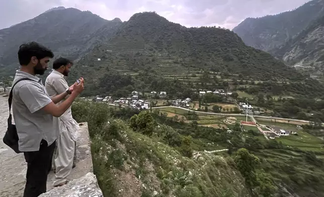 Local residents take picture with their mobile phones of Indian side Kashmir, at a view point from Pakistan side on the Line of Control, the de facto border dividing Pakistan and Indian Kashmir, in Chilhana, some 45 kilometres (27 miles) from Muzaffarabad, the capital of Pakistan controlled Kashmir, Thursday, May 1, 2025. (AP Photo/M.D. Mughal)