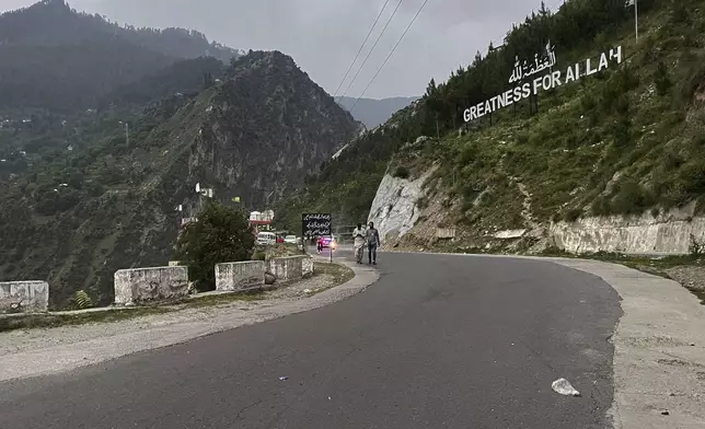 Local residents walk on a highway near on the Line of Control, the de facto border dividing Pakistan and Indian Kashmir, in Chilhana, some 45 kilometres (27 miles) from Muzaffarabad, the capital of Pakistan controlled Kashmir, Thursday, May 1, 2025. (AP Photo/M.D. Mughal)