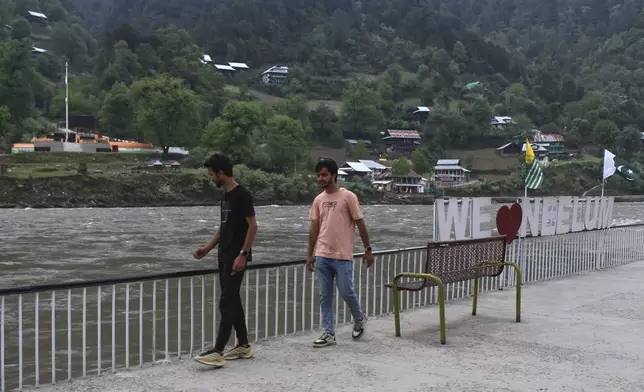 Local residents look at the Indian side of Kashmir from an empty tourists point in Karen, in the Neelum Valley near on the Line of Control, the de facto border that divides the disputed region of Kashmir, some 93 kilometres (58 miles) from Muzaffarabad, the capital of Pakistan controlled Kashmir, Thursday, May 1, 2025. (AP Photo/Ishfaq Hussain)