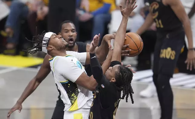 Indiana Pacers center Myles Turner, left, collides with Cleveland Cavaliers guard Darius Garland, right, during the first half of Game 3 in the Eastern Conference semifinals of the NBA basketball playoffs in Indianapolis, Friday, May 9, 2025. (AP Photo/Michael Conroy)