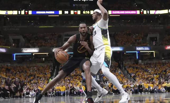 Cleveland Cavaliers center Evan Mobley (4) dribbles the ball against Indiana Pacers center Myles Turner (33) during the first half of Game 3 in the Eastern Conference semifinals of the NBA basketball playoffs in Indianapolis, Friday, May 9, 2025. (AP Photo/Michael Conroy)