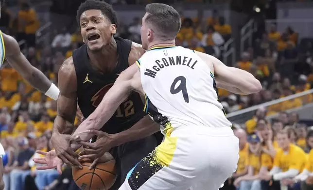 Indiana Pacers guard T.J. McConnell (9) hits the ball away from Cleveland Cavaliers forward De'Andre Hunter (12) during the first half of Game 3 in the Eastern Conference semifinals of the NBA basketball playoffs in Indianapolis, Friday, May 9, 2025. (AP Photo/Michael Conroy)