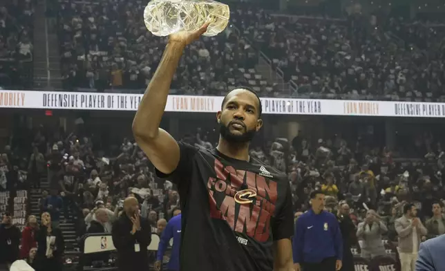 Cleveland Cavaliers forward Evan Mobley holds his Defensive Player of the Year trophy before Game 1 in the Eastern Conference semifinals of the NBA basketball playoffs against the Indiana Pacers, Sunday, May 4, 2025, in Cleveland. (AP Photo/Sue Ogrocki)