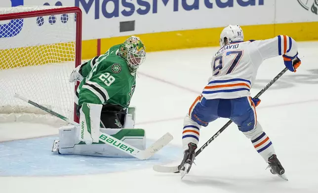 FILE - Edmonton Oilers center Connor McDavid (97) prepares to shoot against Dallas Stars goaltender Jake Oettinger (29) during overtime in Game 1 of the NHL hockey Western Conference Stanley Cup playoff finals, May 23, 2024, in Dallas. (AP Photo/Tony Gutierrez, File)