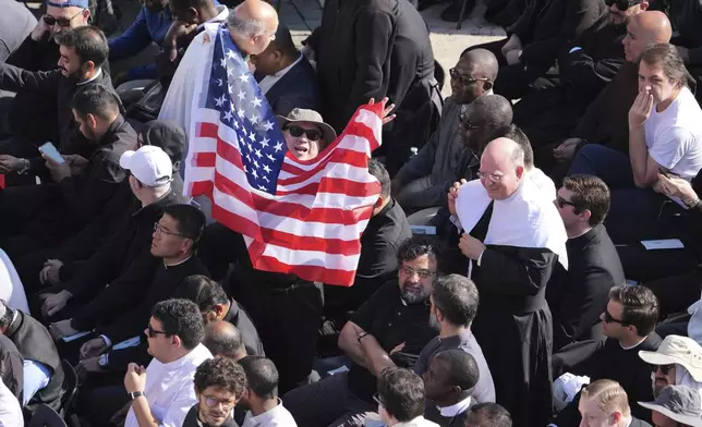 A man waves a U.S. flag as Pope Leo XIV tours St. Peter's Square on his popemobile at the Vatican prior to the inaugural Mass of his pontifcate, Sunday, May 18, 2025. (AP Photo/Jacquelyn Martin, Pool)