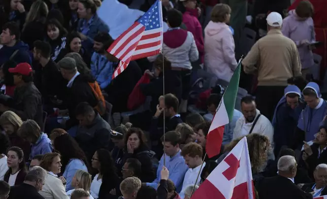A United States' flag is seen in the crowd ahead of Pope Leo XIV's formal inauguration of his pontificate with a Mass in St. Peter's Square attended by heads of state, royalty and ordinary faithful, Sunday, May 18, 2025. (AP Photo/Gregorio Borgia)