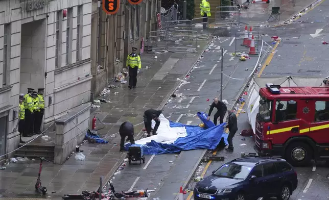 Police and emergency personnel deal with an incident after a car collided with pedestrians near the Liver Building during the Premier League winners parade in Liverpool, England, Monday, May 26, 2025.(AP Photo/Jon Super)