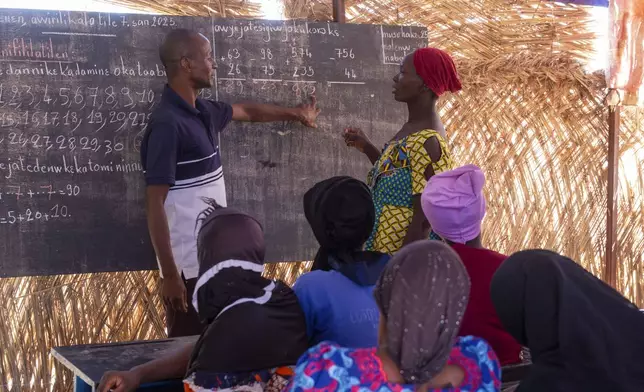 Sidi Yaya Sangare, left, teaches Bambara in a makeshift classroom in the village of Mountougoula, Mali, April 7, 2025. (AP Photo/Saydou Camara)