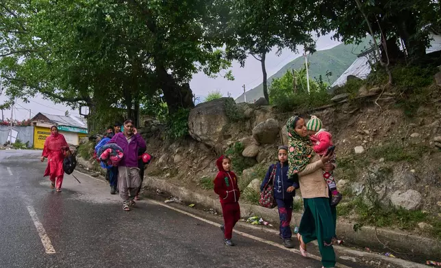 Kashmiri villagers walk towards safer places after they evacuated their village after overnight shelling from Pakistan at Gingal village in Uri district, Indian controlled Kashmir, Friday, May 9, 2025. (AP Photo/Dar Yasin)