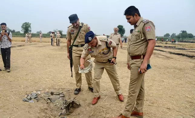 Indian police personnel inspect an object suspected to be parts of a projectile intercepted by the Indian Army at Nahlan village on the outskirts of Jalandhar, India, Saturday, May 10, 2025. (AP Photo)
