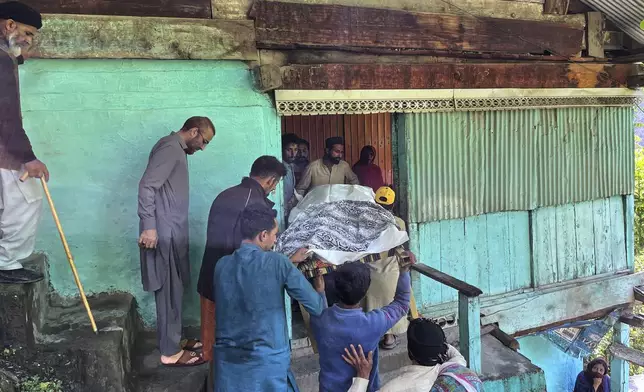People carry the body of a woman, who was killed in the overnight Indian shelling, near Shah Kot, in Neelum Vallery, a district of Pakistan's administered Kashmir, Friday, May 9, 2025. (AP Photo/M.D. Mughal)