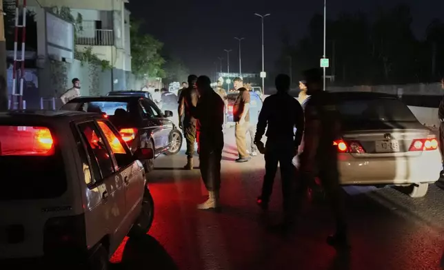 Pakistani police officers remove vehicles and people from the main entry of Nur Khan airbase following an Indian missile strike in Rawalpindi, Pakistan, Saturday, May 10, 2025. (AP Photo/Anjum Naveed)