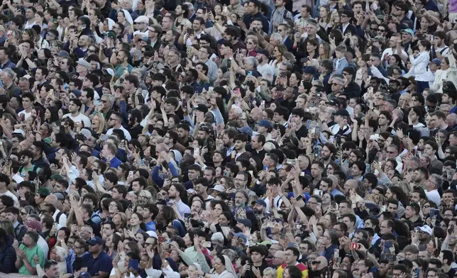 Poeple watch newly elected Pope Leo XIV as he appears at the balcony of St. Peter's Basilica at the Vatican, Thursday, May 8, 2025. (AP Photo/Markus Schreiber)