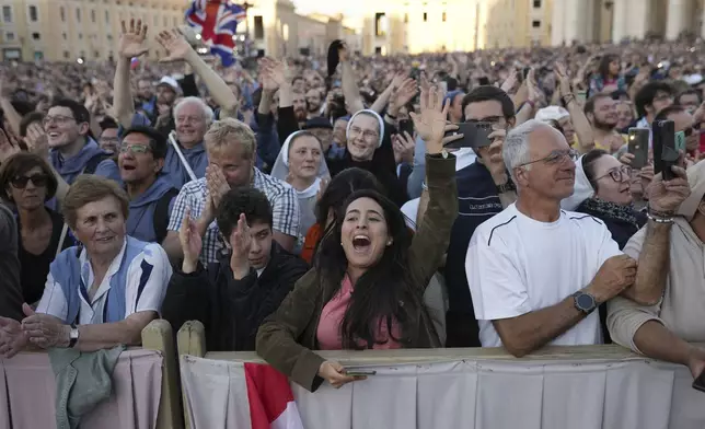 Faithful react after the announcement of the newly elected Pope Leo XIV at the Vatican, Thursday, May 8, 2025. (AP Photo/Francisco Seco)