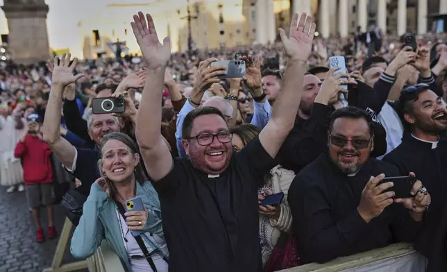 Faithful react after the announcement of the newly elected Pope Leo XIV at the Vatican, Thursday, May 8, 2025. (AP Photo/Francisco Seco)