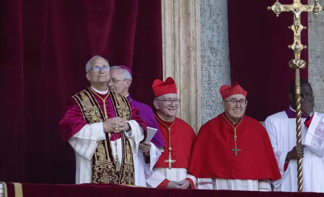 Newly elected Pope Leo XIV, left, formerly Cardinal Robert Francis Prevost, appears on the central loggia of St. Peter's Basilica at the Vatican shortly after his election as the 267th pontiff of the Roman Catholic Church, Thursday, May 8, 2025. (AP Photo/Domenico Stinellis)