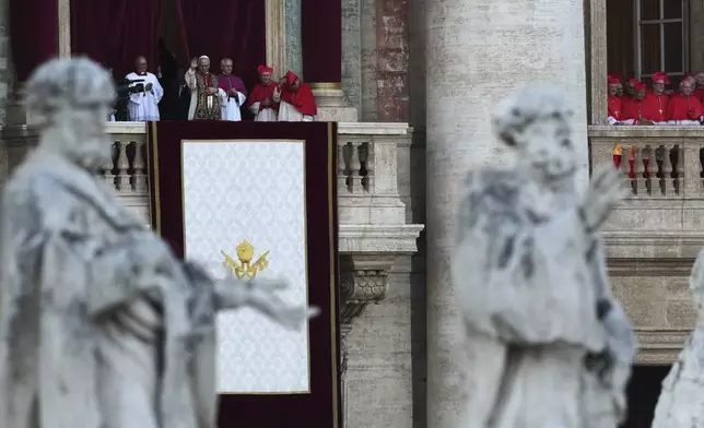 Pope Leo XIV greets the crowd from the balcony of St Peter's Basilica after his election, at the Vatican, Thursday, May 8, 2025. (AP Photo/Antonio Calanni)