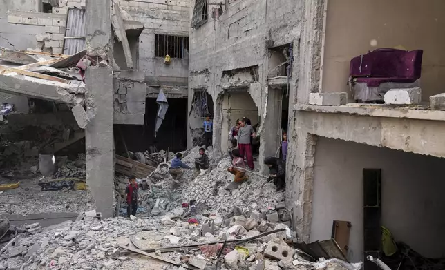 Palestinians inspect the rubble of the Al-Lahham family's home, destroyed by Israeli airstrikes in Khan Younis, Gaza Strip, on Thursday, May 15, 2025. (AP Photo/Abdel Kareem Hana)