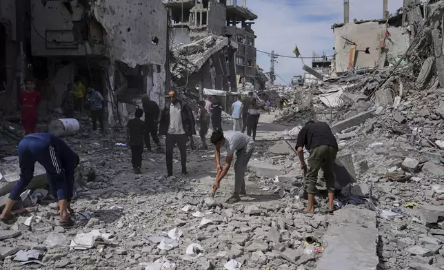 Palestinians clean the rubble along a road beside a clinic destroyed by Israeli airstrikes in Jabalia, in the northern Gaza Strip, on Thursday, May 15, 2025. (AP Photo/Jehad Alshrafi)