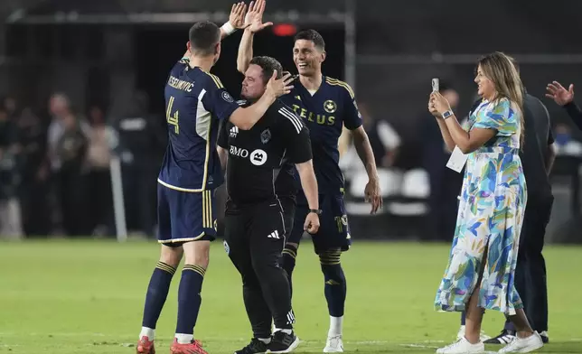 Vancouver Whitecaps defender Ranko Veselinović (4) and forward Damir Kreilach (19) celebrate after defeating Inter Miami in a CONCACAF Champions Cup second-leg semifinal soccer match, Wednesday, April 30, 2025, in Fort Lauderdale, Fla. (AP Photo/Lynne Sladky)