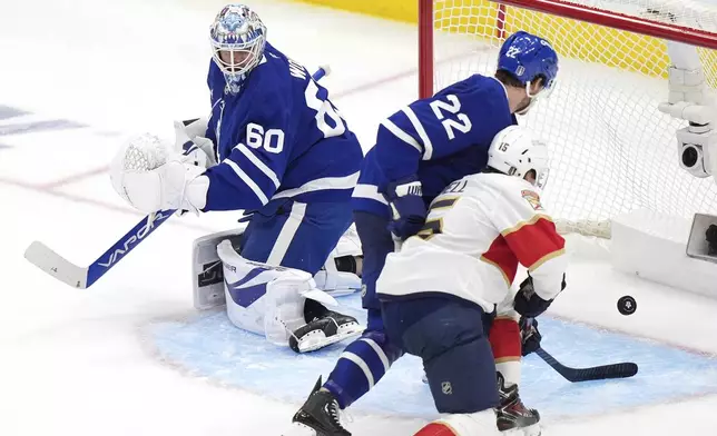Toronto Maple Leafs goaltender Joseph Woll (60), Maple Leafs defenseman Jake McCabe (22) and Florida Panthers forward Anton Lundell (15) watch the puck go into the net as the Panthers score during the third period of Game 1 in an NHL hockey second-round playoff series in Toronto, Monday, May 5, 2025. (Frank Gunn/The Canadian Press via AP)
