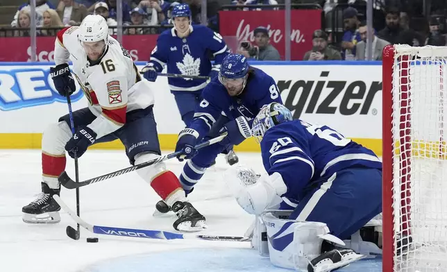 Toronto Maple Leafs goaltender Joseph Woll (60) makes a save against Florida Panthers forward Aleksander Barkov (16) during the third period of Game 1 in an NHL hockey second-round playoff series in Toronto, Monday, May 5, 2025. (Nathan Denette/The Canadian Press via AP)