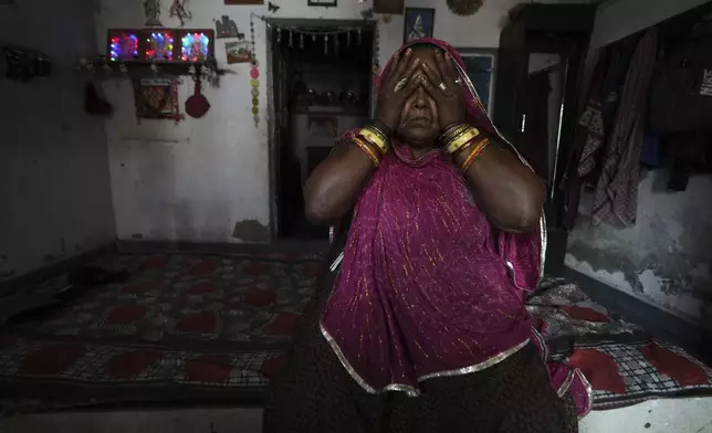 Shantaben Vanzara, wearing a wristwatch-style health monitor to study how heat affects vulnerable communities, wipes her face inside her house in Ahmedabad, India, Wednesday, April 2, 2025. (AP Photo/Ajit Solanki)