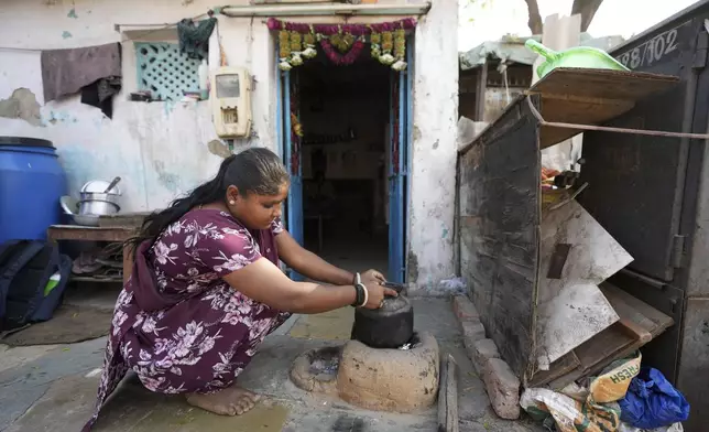 Puja Vanzara, wearing a wristwatch-style health monitor to study how heat affects vulnerable communities, works at her house in Vanzara Vas in Ahmedabad, India, Wednesday, April 2, 2025. (AP Photo/Ajit Solanki)