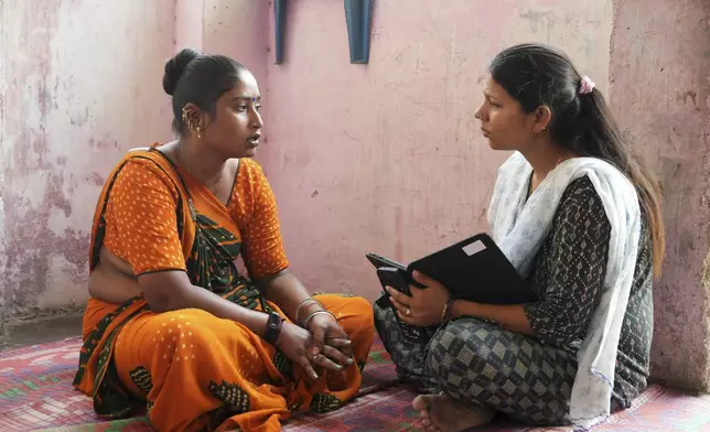 Data collector Komal Parmar, right, talks with Sapnaben Chunara to get heat related information in Ahmedabad, India, Wednesday, April 2, 2025. (AP Photo/Ajit Solanki)