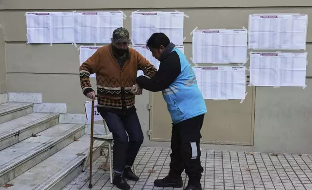 A city worker aids a voter during city legislature elections in Buenos Aires, Argentina, Sunday, May 18, 2025. (AP Photo/Rodrigo Abd)