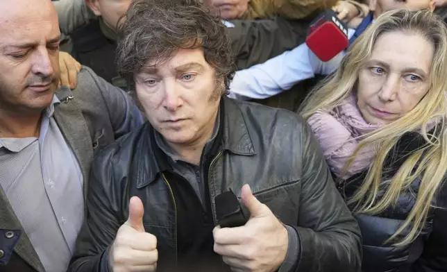 Argentina’s President Javier Milei gives a thumbs-up after voting, accompanied by his sister Karina Milei, right, during city legislature elections in Buenos Aires, Argentina, Sunday, May 18, 2025. (AP Photo/Rodrigo Abd)