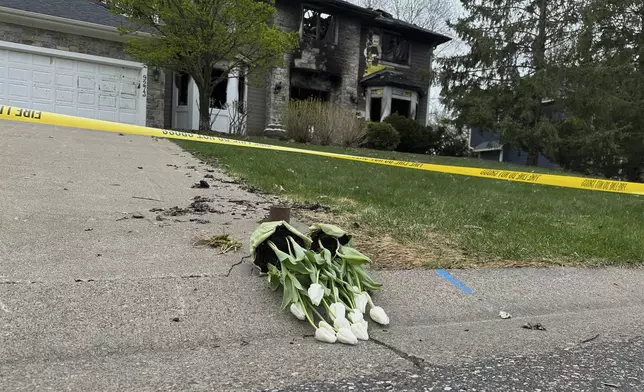 Flowers are left in the driveway at the home of Jill Sobule on Friday, May 2, 2025, in Woodbury, Minn., a day after a fire engulfed the house, killing the 66-year-old singer-songwriter. (AP Photo/Amy Forliti)