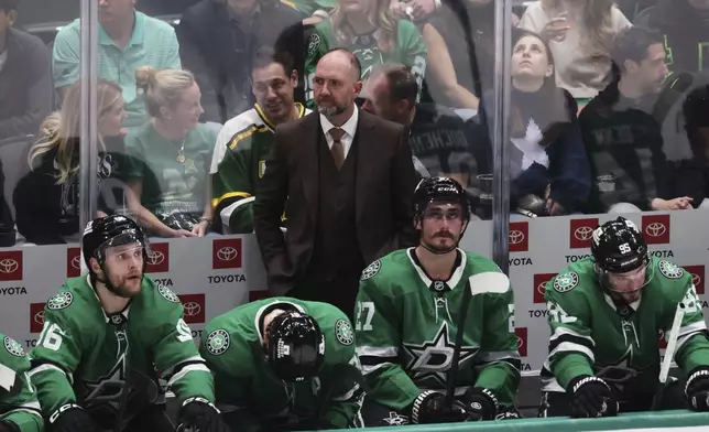 Dallas Stars head coach Peter DeBoer stands behind players on the bench during the second period of Game 5 of the Western Conference finals in the NHL hockey Stanley Cup playoffs against the Edmonton Oilers, Thursday, May 29, 2025, in Dallas. (AP Photo/Gareth Patterson)
