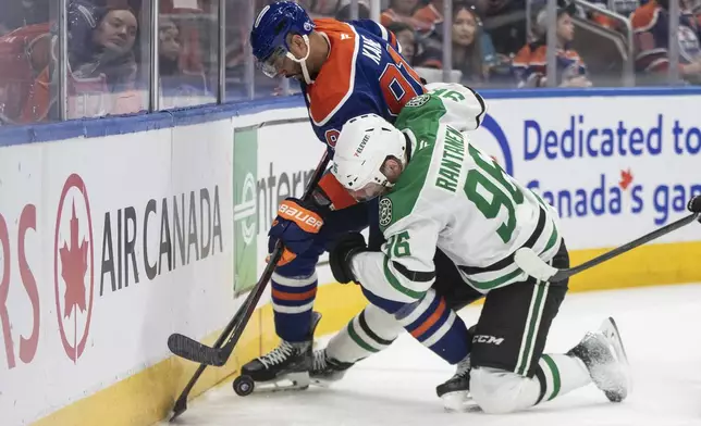 Dallas Stars' Mikko Rantanen (96) and Edmonton Oilers' Evander Kane, top, battle for the puck during the second period of Game 3 of the NHL hockey Stanley Cup Western Conference finals in Edmonton, Alberta, Sunday, May 25, 2025. (Jason Franson/The Canadian Press via AP)