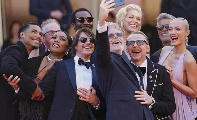 Greg Tarzan Davis, from left, editor Eddie Hamilton, Angela Bassett, Tramell Tillman, Tom Cruise, director Christopher McQuarrie, Hannah Waddingham, Simon Pegg, Esai Morales, and Pom Klementieff take a selfie upon arrival at the premiere of the film 'Mission: Impossible - The Final Reckoning' at the 78th international film festival, Cannes, southern France, Wednesday, May 14, 2025. (Photo by Scott A Garfitt/Invision/AP)