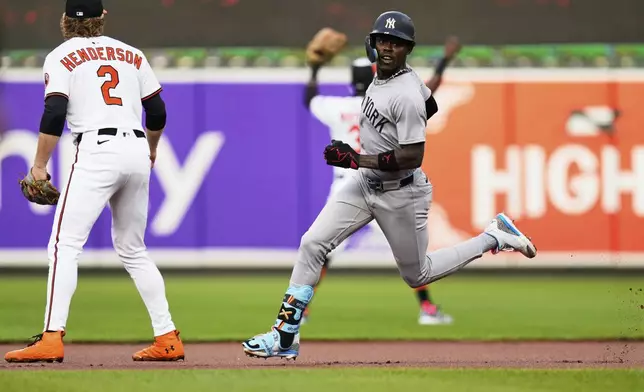 New York Yankees' Jazz Chisholm Jr., right, looks while advancing toward third base past Baltimore Orioles shortstop Gunnar Henderson (2) on a fielding error by Baltimore Orioles right fielder Ramon Laureano during the first inning of a baseball game, Tuesday, April 29, 2025, in Baltimore. (AP Photo/Stephanie Scarbrough)