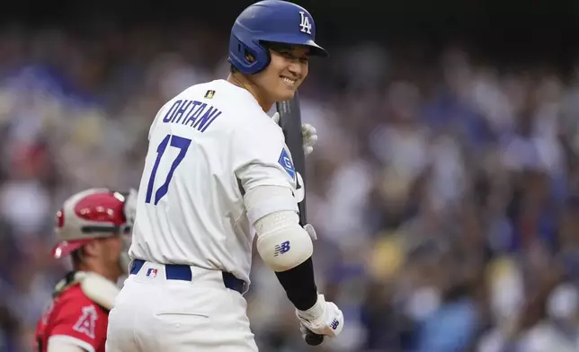 Los Angeles Dodgers' Shohei Ohtani smiles toward the Los Angeles Angels dugout as he steps up to bat during the first inning of a baseball game Saturday, May 17, 2025, in Los Angeles. (AP Photo/Mark J. Terrill)