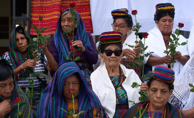 Indigenous women wait outside the Supreme Court to wait for an expected ruling, by a different court, in a case against three former paramilitary fighters who were trained by the military and are accused of raping 36 women four decades ago during Guatemala's civil war, in Guatemala City, Friday, May 30, 2025. (AP Photo/Moises Castillo)