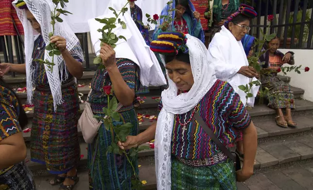 Indigenous women arrive outside the Supreme Court to wait for an expected ruling, by a different court, in a case against three former paramilitary fighters who were trained by the military and are accused of raping 36 women four decades ago during Guatemala's civil war, in Guatemala City, Friday, May 30, 2025. (AP Photo/Moises Castillo)