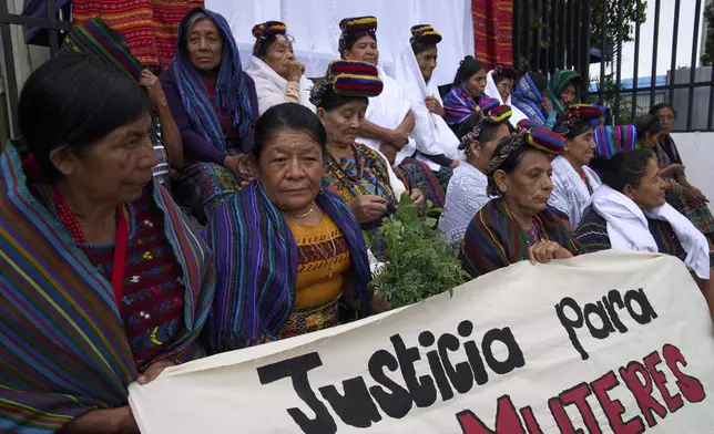 Indigenous women hold the sign in Spanish "Justice for women" outside the Supreme Court as they wait for an expected ruling, by a different court, in a case against three former paramilitary fighters who were trained by the military and are accused of raping 36 women four decades ago during Guatemala's civil war, in Guatemala City, Friday, May 30, 2025. (AP Photo/Moises Castillo)
