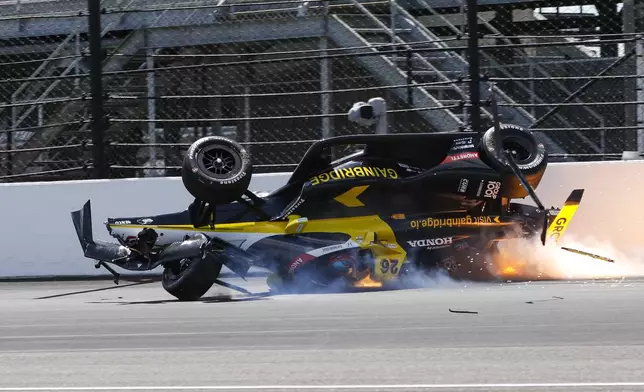 The car driven by Colton Herta slides along the track after becoming airborne after hitting the wall in the first turn during a qualification attempt for the Indianapolis 500 auto race at Indianapolis Motor Speedway in Indianapolis, Saturday, May 17, 2025. (AP Photo/Kirk DeBrunner)