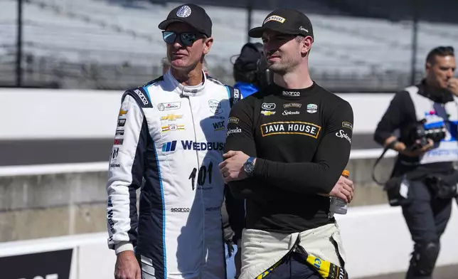 Ryan Hunter-Reay, left, and Alexander Rossi talk as they wait for their turn during qualification for the Indianapolis 500 auto race at Indianapolis Motor Speedway in Indianapolis, Saturday, May 17, 2025. (AP Photo/Michael Conroy)