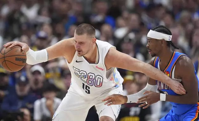 Denver Nuggets center Nikola Jokic, left, struggles to control the ball as Oklahoma City Thunder guard Shai Gilgeous-Alexander defends in the second half of Game 6 in the Western Conference semifinals of the NBA basketball playoffs Thursday, May 15, 2025, in Denver. (AP Photo/David Zalubowski)