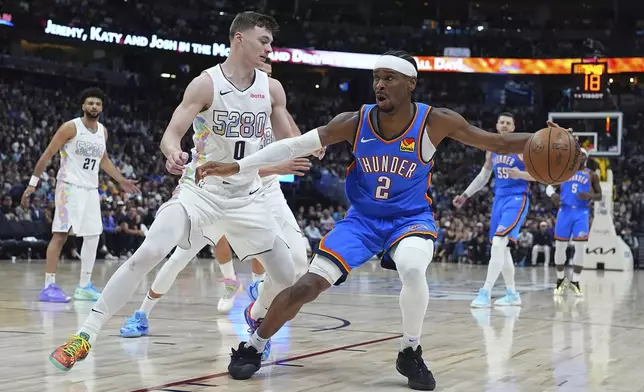 Oklahoma City Thunder guard Shai Gilgeous-Alexander, right, drives to the basket as Denver Nuggets guard Christian Braun defends in the second half of Game 6 in the Western Conference semifinals of the NBA basketball playoffs Thursday, May 15, 2025, in Denver. (AP Photo/David Zalubowski)