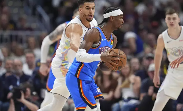 Oklahoma City Thunder guard Shai Gilgeous-Alexander, front, drives the lane as Denver Nuggets forward Michael Porter Jr. defends in the first half of Game 6 in the Western Conference semifinals of the NBA basketball playoffs Thursday, May 15, 2025, in Denver. (AP Photo/David Zalubowski)