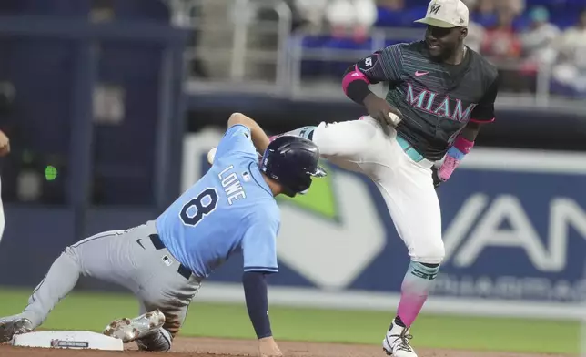 Miami Marlins second baseman Ronny Simon (41) tags Tampa Bay Rays' Brandon Lowe (8) during the first inning of a baseball game, Saturday, May 17, 2025, in Miami. (AP Photo/Marta Lavandier)