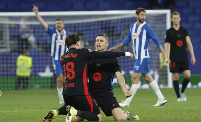 Barcelona players celebrate at the end of the Spanish La Liga soccer match between Barcelona and Espanyol at Lluis Companys Olympic Stadium in Barcelona, Spain, Thursday, May 15, 2025. (AP Photo/Joan Monfort)