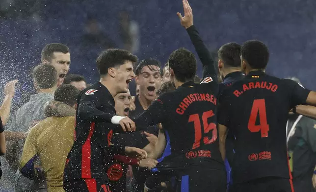 Barcelona players celebrate at the end of the Spanish La Liga soccer match between Barcelona and Espanyol at Lluis Companys Olympic Stadium in Barcelona, Spain, Thursday, May 15, 2025. (AP Photo/Joan Monfort)